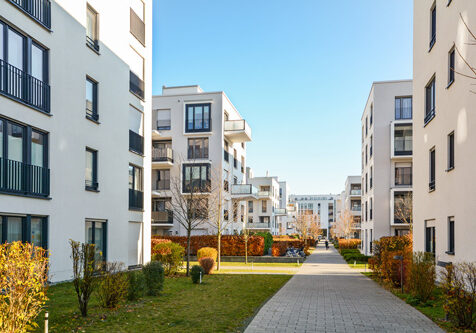 Mehrfamilienhäuser im Sonnenschein vor blauem Himmel