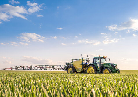 Landwirtschaftsgerät auf einem grünen Feld mit blauem Himmel.